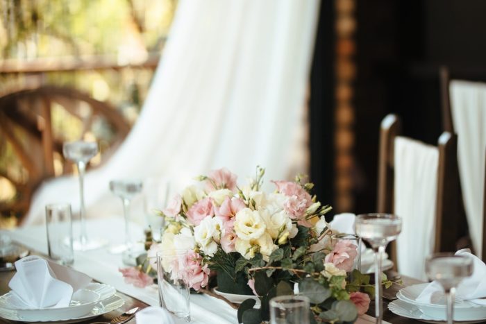 Floral centerpiece on dining table at wedding venue.