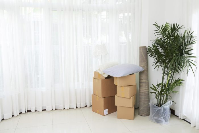 Interior shot of new modern real estate with unpacked boxes and stuff in stack